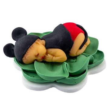 Bebe Mickey dormind pe o floare verde din pasta de zahar